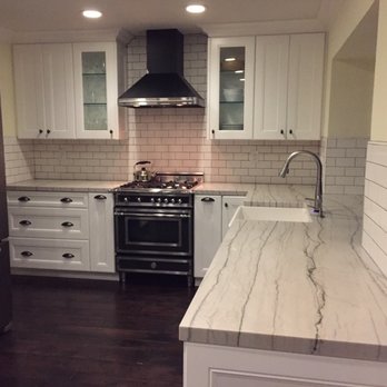 Euro Laguna Marble - a kitchen with white cabinets and stainless steel appliances - General Contractors Near Me - Anaheim, California