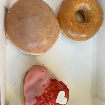 Krispy Kreme - Berry heart donut. Raspberry filled donut. Original Glazed Dozen. And one chocolate heart already being eaten. - Donuts Near Me - Concord, California