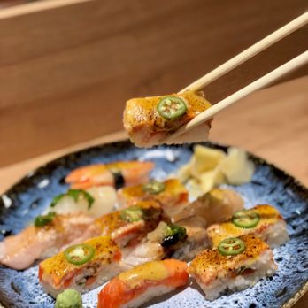 Uma Sushi - a close up of a plate of sushi with chopsticks - Japanese Near Me - Vancouver, British Columbia