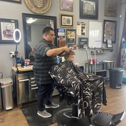 Midtown Barbershop - Carlos cutting Henry's hair.
