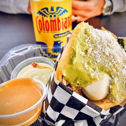 Biikho Colombian Food - Chicken arepa! Warm crispy shell with chicken, quail egg, guacamole and dipping sauces. Colombiana peeking in the background