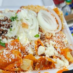 Munching It - Red chilaquiles with 2 eggs and asada sour cream cheese onions and cilantro.