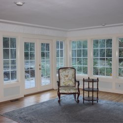 Forbes Painting - Living room with many windows, wainscoting and molding.