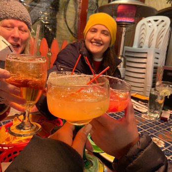 Cafe Sol Azteca - Three margaritas "Cheers"-ing with a corona. Table is outside with a heat lamp in the back. - Mexican Near Me - Newton, Massachusetts