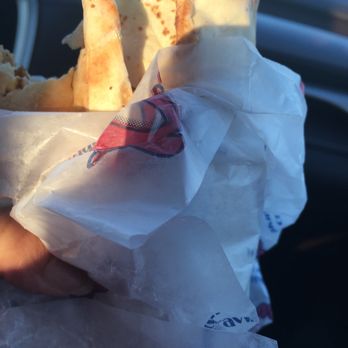 Osmow's Shawarma - a hand holding a sandwich wrapped in paper - Mediterranean Near Me - Georgetown, Ontario