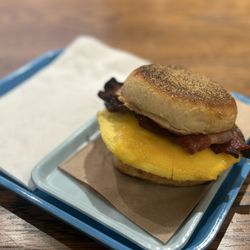 Visible Voice Books - BODEGA CAT ($9) sandwich with egg, applewood smoked bacon, cheddar cheese (light), hot pepper jam on an English muffin - on 10 January 2026