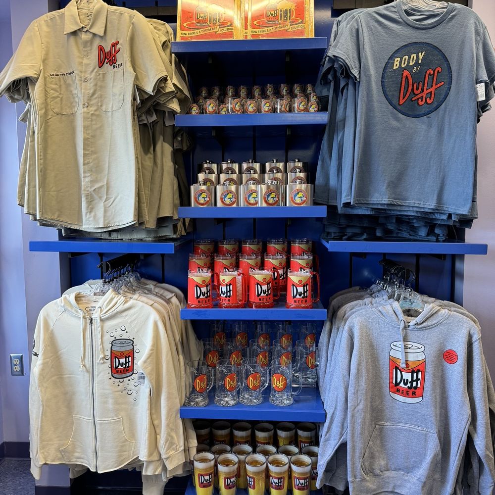 Kwik-E-Mart - ows a variety of shirts on display - Donuts Near Me - Universal City, California