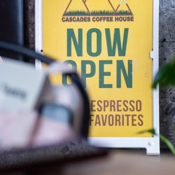 Cascades Coffee House - "Now open" sandwichboard sign; booth in back, shot taken from small table