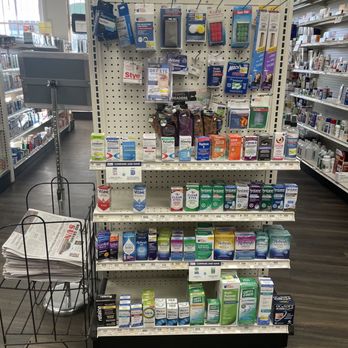 Fairview Pharmacy - Vision and ear care products next to the local newspaper (Rio Grande SUN) - Pharmacy aisle with eye and ear care products, including eye drops, ear plugs, and related accessories on a pegboard display. - Drugstores Near Me - Espanola, New Mexico