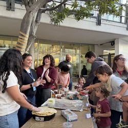 Families gather on the patio for a fun outdoor Community Shabbat Dinner