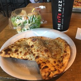 Calzone meal with Cesar salad and drink.