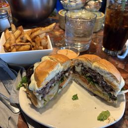 Vintage burger double patty with fries and a soda .
