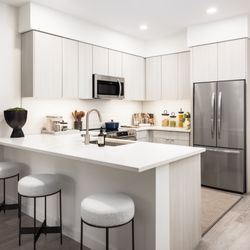 Forge Apartments - A kitchen with a large island with three stools