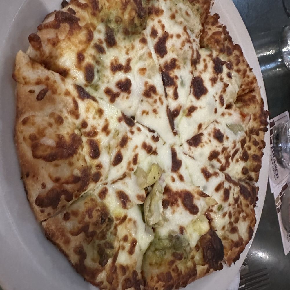 Veggie flatbread pizza with pesto sauce and artichokes