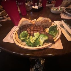 Cattleman's Club Steakhouse - Ribeye cooked medium, with steamed broccoli and baked potato with cheese and bacon.