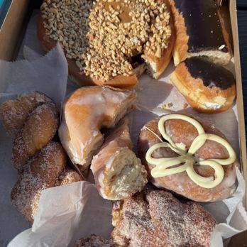 Donut Central - Bad donuts - A variety of donuts with different toppings, glazes, and fillings are displayed in a box at Donut Central in Columbus, Indiana. - Donuts Near Me - Columbus, Indiana