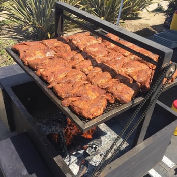 Tri-Tip Man - a grill with meat cooking on it - Food Trucks Near Me