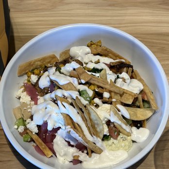 CAVA - Brown basmati rice, grilled chicken, pickled onions, hummus, crazy feta sauce, tomatoes, cucumbers, pita crisps, corn. - Salad Near Me - Coppell, Texas