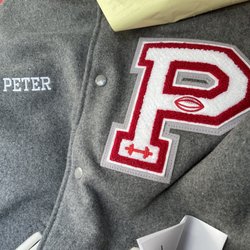 On The Cuff - Letterman jacket with name embroidered on front and a patch attached.