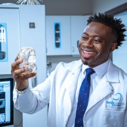 Dr. A looking at tooth model at Smile Design Dental Studio