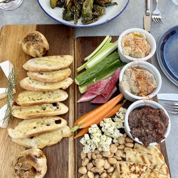 Sevys Bar and Kitchen - Three epic appetizers: Brussel sprouts with peppers, roasted garlic with Brie and crostini, and the Mezze plate. - Bars Near Me - Aptos, California Sevys Bar and Kitchen - Three epic appetizers: Brussel sprouts with peppers, roasted garlic with Brie and crostini, and the Mezze plate. - Bars Near Me - Aptos, California
