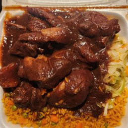 Brown stew chicken with vegetable rice and cabbage.