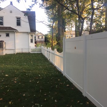 Great Escape - a white fence in front of a white house - Fences & Gates Near Me