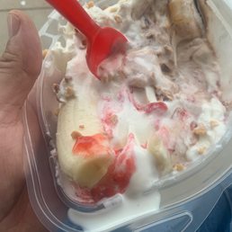 a hand holding a container of ice cream and a banana