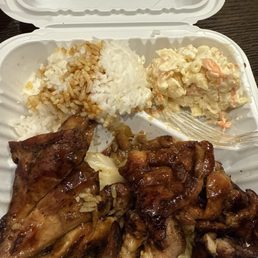 Chicken on top of steamed cabbage with a side of white rice and Mac salad..