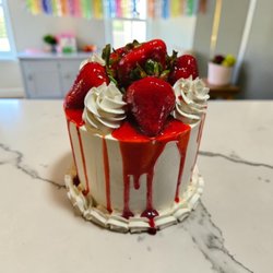 A four-layer strawberry cake featuring a fresh strawberry filling crafted from organic strawberries.