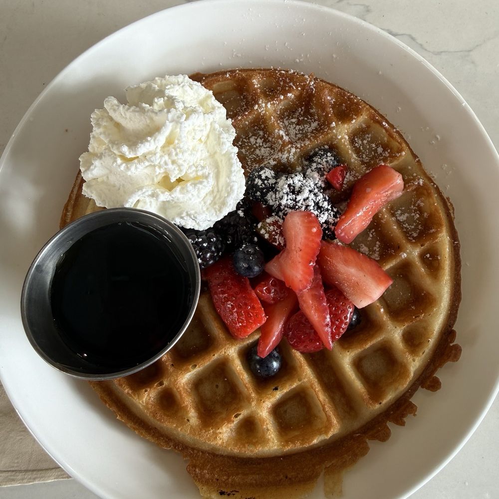 Waffle with syrup, whipped cream and fresh fruit (blackberries and strawberries)