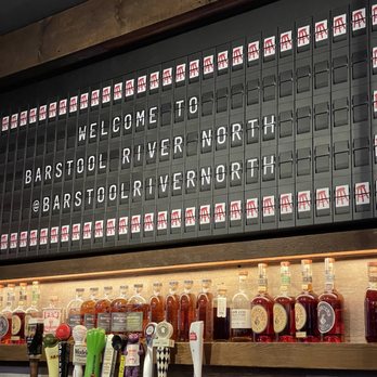 Barstool - a bar with a large menu on the wall - Sports Bars Near Me - Chicago, Illinois