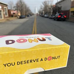 John's Donuts - John's donut box that says "you deserve a donut" with the St. Louis arch in the background.