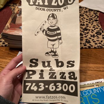 Fatzo's Subs & Pizza - a person holding a sign - Food Court Near Me - Sturgeon Bay, Wisconsin