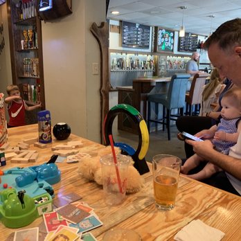 Moondog Growlers - a man sitting at a table with a baby - Beer Bar Near Me - Dunwoody, Georgia Moondog Growlers - a man sitting at a table with a baby - Beer Bar Near Me - Dunwoody, Georgia