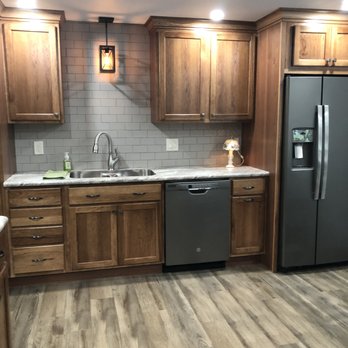 John Gordon Contracting - a kitchen with wood cabinets and stainless steel appliances - General Contractors Near Me