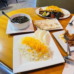 Chicken Koobideh Plate (in back), Ghormeh Sabzi (left) and rice, bread and half-eaten Beans appetzier.