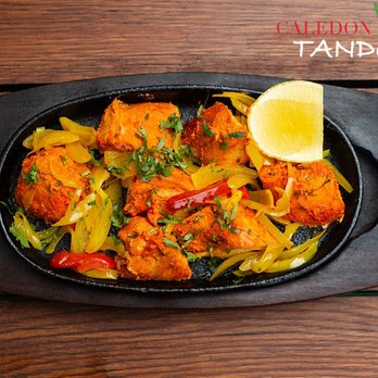 Caledon Tandoori - a pan of food on a wooden table - Indian Near Me - Caledon, Ontario