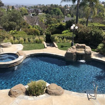 Alan Smith Pool Plastering & Remodeling - After  --  New natural stone coping, new waterline tile, renewed rock features, pebble finish and added handrails - Pool & Hot Tub Service Near Me - Orange, California