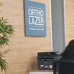 OrthoLazer - Signs in front desk area.
