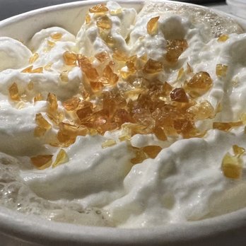 Starbucks - Caramel Brûlée Latte' - My seasonal favorite ~ - A beverage in a white cup topped with a generous swirl of whipped cream and sprinkled with caramelized sugar crystals. The drink appears to be a specialty coffee, possibly a caramel brûlée latte, with the toppings adding a decorative and flavorful touch. - Coffee & Tea Near Me - Temecula, California