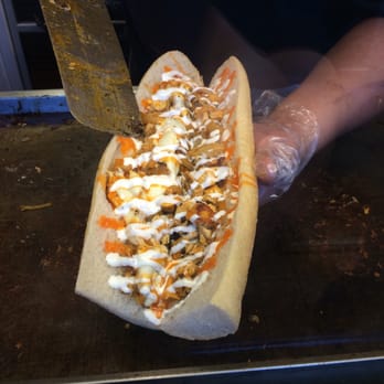 Rascals - a person cutting a sandwich with a knife - Cheesesteaks Near Me - Whitehall, Pennsylvania