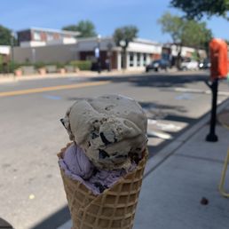 a person holding a cone of ice cream a person holding a cone of ice cream