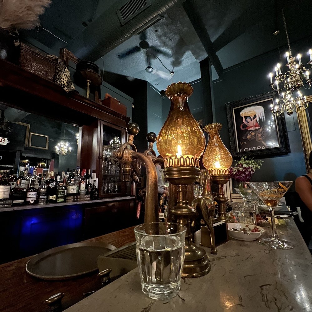 Cheval - a bar with a table and a chandelier - Cocktail Bars Near Me - Kansas City, Missouri