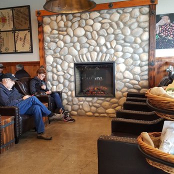 Woods Coffee - The leather couch seating section by the electric fireplace. - Coffee & Tea Near Me - Mount Vernon, Washington