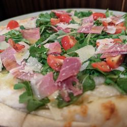 Il limone - L'antonia. Garlic pizza with Arugula, tomato and prosciutto