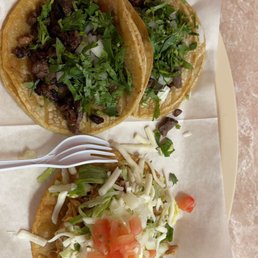 two tacos on a plate with a fork two tacos on a plate with a fork