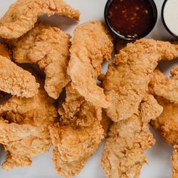 Sexy Sammies 10th - A tray full of chicken tenders with a variety of dipping sauces on the side