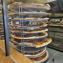 The Pizza Stop - Assorted pizza slices on a rack