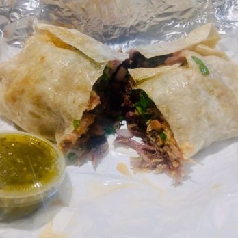 Zamora Bros - Carnitas Burrito Cut in half with green salsa on the side - Mexican Near Me - Los Angeles, California Zamora Bros - Carnitas Burrito Cut in half with green salsa on the side - Mexican Near Me - Los Angeles, California